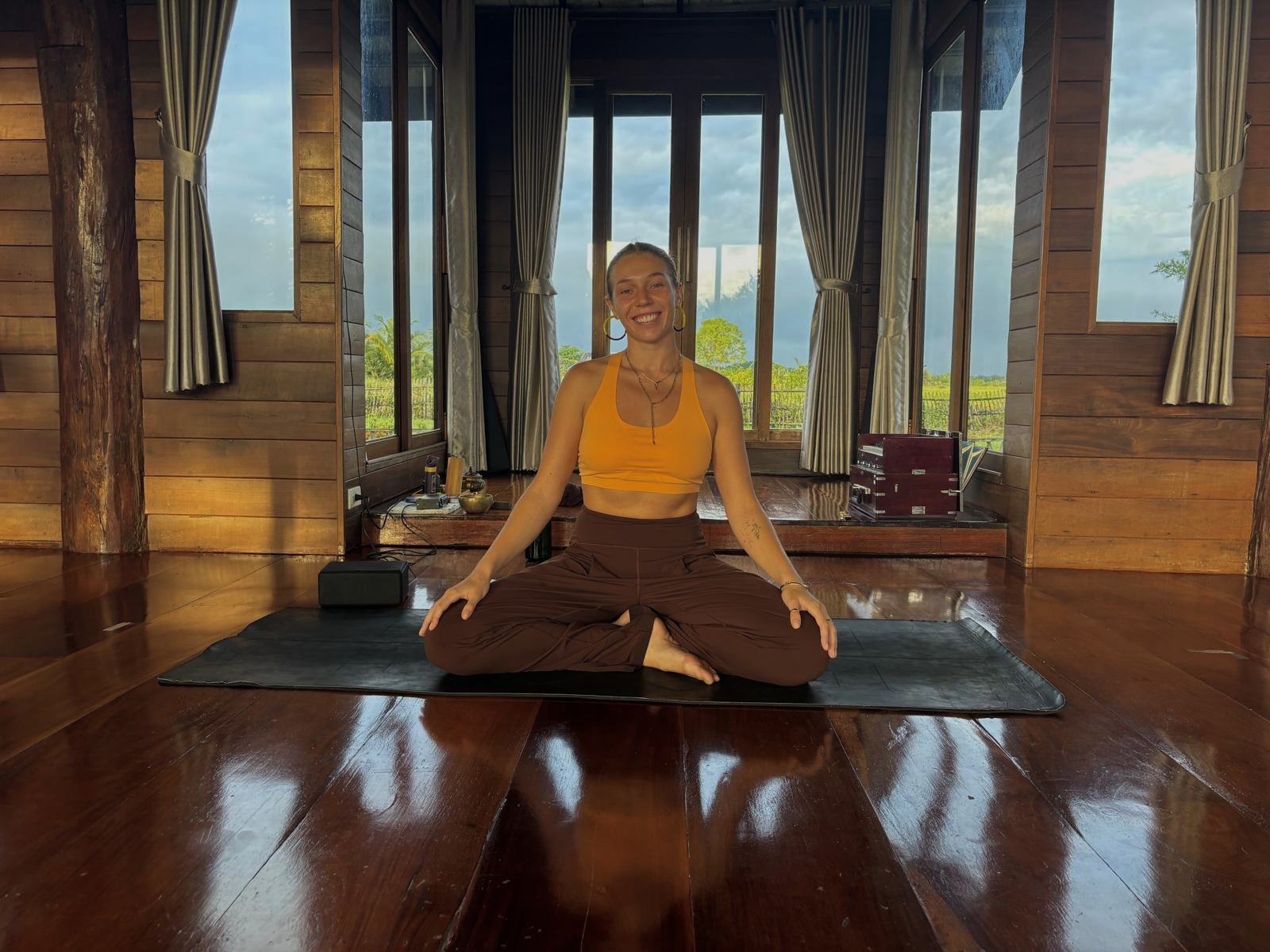 Gina, SAMA yoga teacher, seated in a calm meditative pose